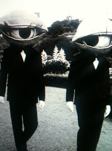 Vintage photograph featuring two individuals dressed as giant eyes courtesy of ancientfaces.com.