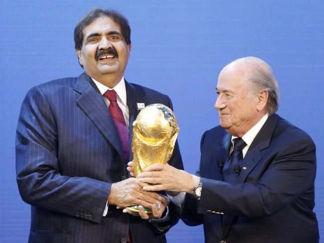 Emir of Qatar Sheikh Hamad bin Khalifa Al Thani (left) receives World Cup trophy from FIFA President Sepp Blatter after the 2010 announcement that Qatar would host the 2022 World Cup