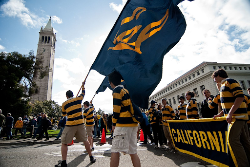 Members of the University of California Rally Committee carry the California banner and wave two of the Cal flags near the Campanile in Berkeley, CA.