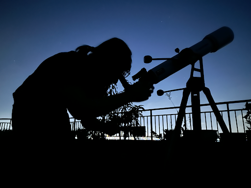 An OHS student peers through a telescope on an Astrobiology assignment.